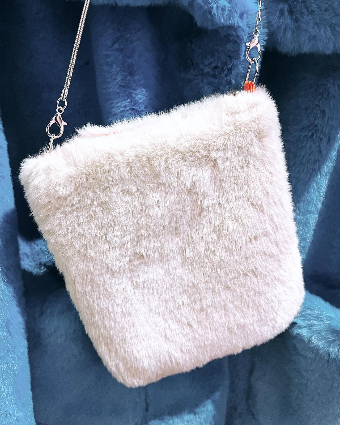 A cream crossbody bag selected by Ella Cru
